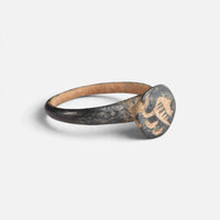 Byzantine bronze ring 'Peristerios' shows its circular bezel device and narrow shoulder at an angle.