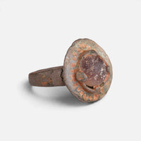 Byzantine bronze ring 'Porphyra' shows its purple setting and decorated bezel border at an angle.