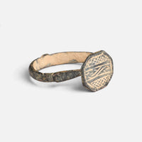 Byzantine bronze ring 'Damianos' shows its octagonal bezel engraving and narrow shoulder at an angle.