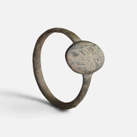 Byzantine bronze ring 'Kassia' shows its worn figural oval bezel and complete hoop at an angle.