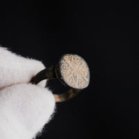 Byzantine bronze signet ring Stellaris held in gloved hand, star and cross bezel visible