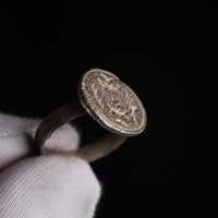 Byzantine silver ring Klados, angled view of disc face and hoop held against a black ground.