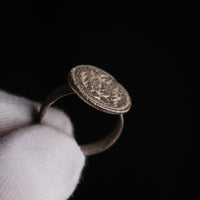 Byzantine silver ring Klados, angled view of disc face and strip hoop against a black ground.