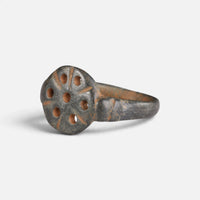 Byzantine bronze ring 'Heliona' shows its pierced circular bezel from the opposite front angle.