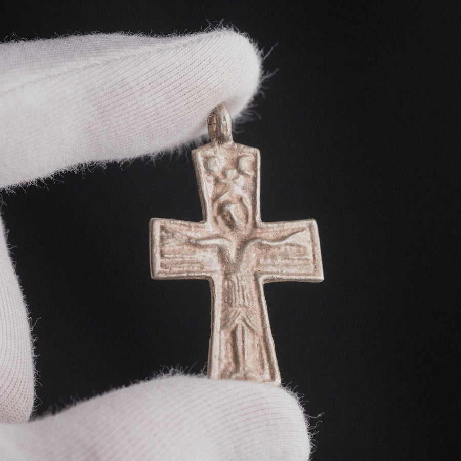 Byzantine silver cross pendant Anastasia held in gloved hand, close-up of Crucifixion relief