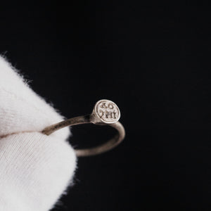 Byzantine silver ring Iesous held in gloved hand showing bezel with Greek letters
