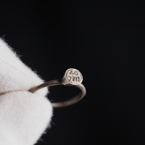 Byzantine silver ring Iesous held in gloved hand showing bezel with Greek letters