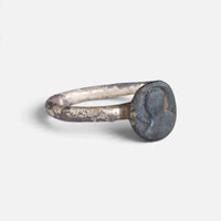 Byzantine ring 'Theodosia' shows its dark disc bezel and pale worn band at an angle.