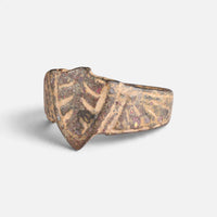 Medieval bronze ring 'Radbert' shows its decorated shield-shaped bezel from the opposite front angle.