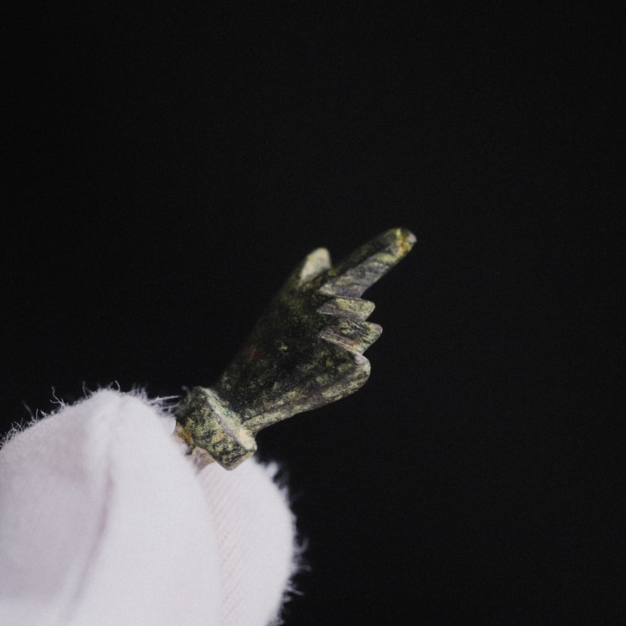 Close detail of the fist on Roman bronze pendant Manicula, folded fingers on either side of the thumb
