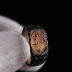 Close-up macro of Roman bronze ring Palmata showing engraved carnelian gem