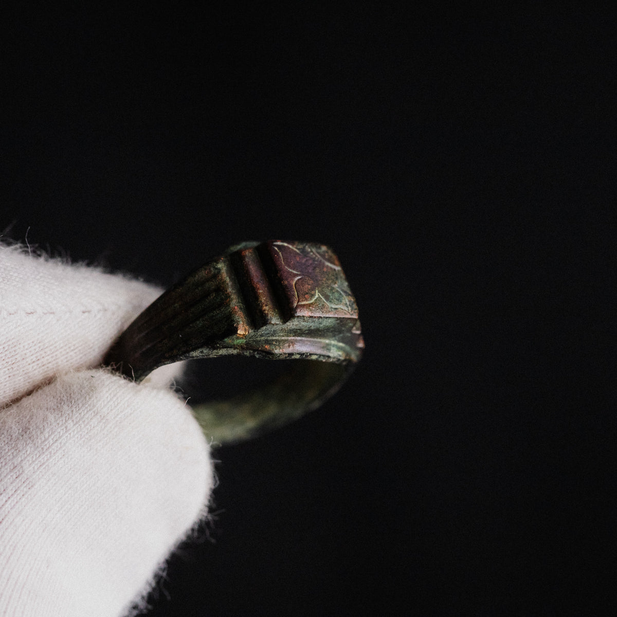 Close-up of Byzantine bronze ring Aetheria bezel showing engraved floral motif in raking light
