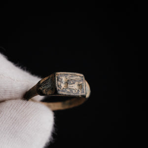 Close-up of Roman bronze ring Grypho held in gloved hand, griffin bezel detail