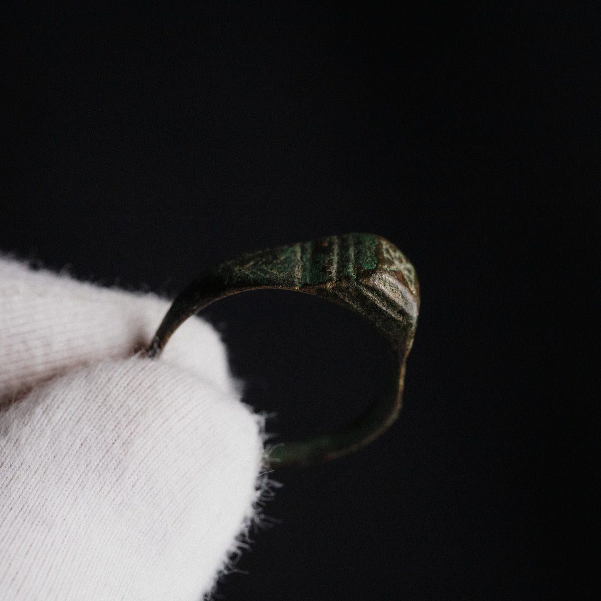 Close-up of Roman bronze ring Numerius bezel showing engraved cross or chi-form device