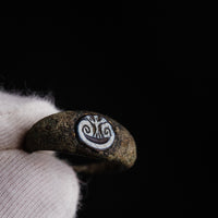 Close-up of Roman bronze ring Volusia held in gloved hand showing intaglio detail