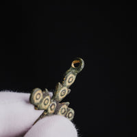 Close-up of suspension loop of Medieval bronze cross pendant 'Rotunda' with ring-and-dot ornaments on the upper arm