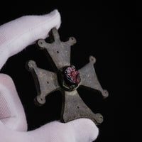 Close-up of the central red cabochon in its raised collet on Medieval bronze cross pendant 'Gemmata'.