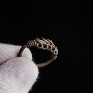 Roman silver wire ring 'Nodus' shows its loop rows and a wound collar while held in a white glove.