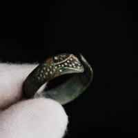 Detail of medieval bronze ring Vesna held in gloved hand, showing punched-dot vine motif