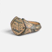 Medieval Islamic bronze ring 'Nasirun' shows its angular bezel engraving and shoulder from the opposite angle.