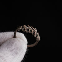 Roman silver wire ring 'Nodus' shows its loop rows and wound shoulders at an angle in a glove.