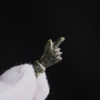 Thumb detail of Roman bronze pendant Manicula, the long thumb pushed through the folded fist