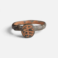 Byzantine bronze ring 'Monogrammos' shows intersecting engraved strokes on its circular bezel from the front.