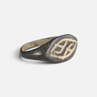 Medieval bronze ring 'Aldhelm' shows its engraved navette bezel and broad shoulder at an angle.