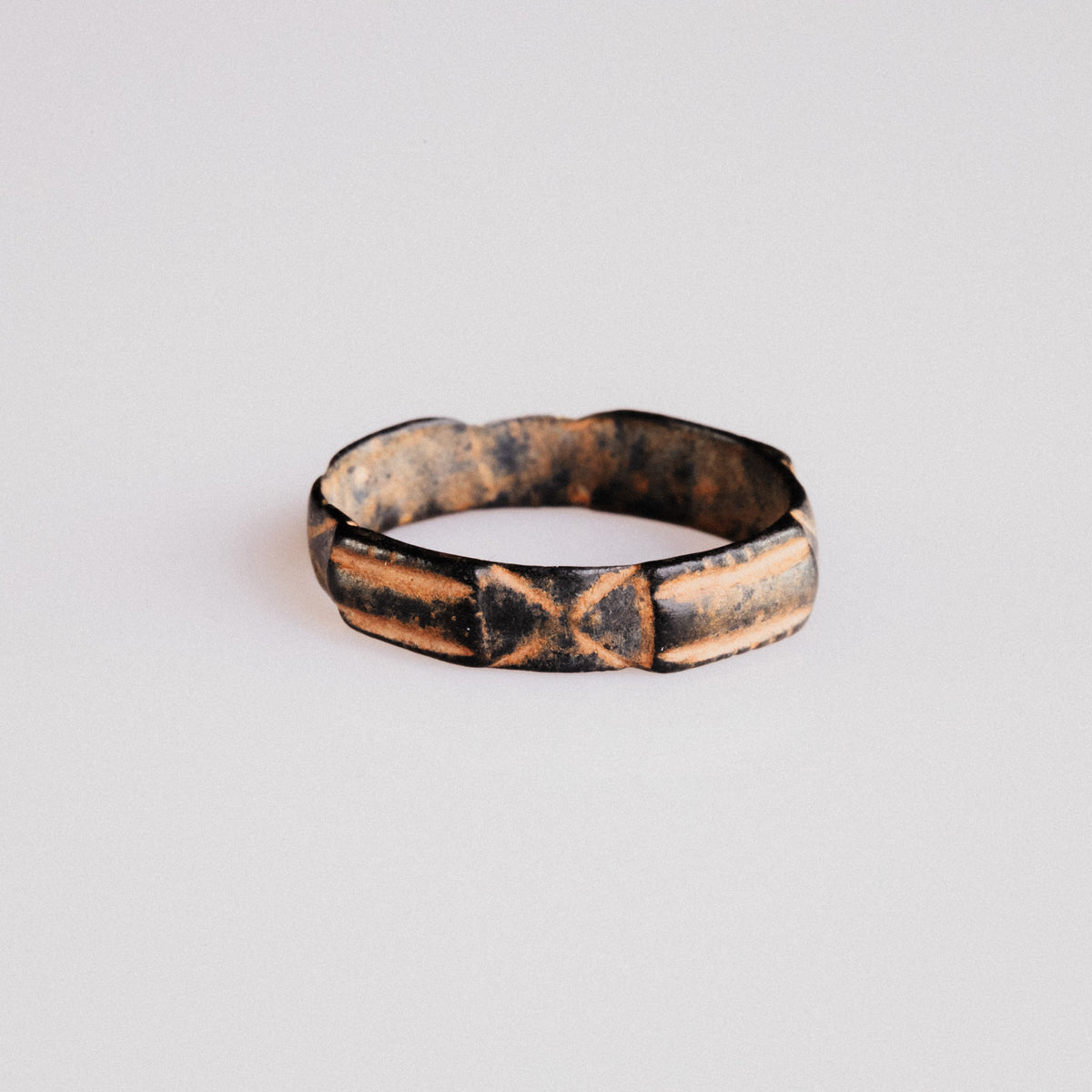 Front view of medieval bronze ring Aldric with dark tenorite patina in incised grooves