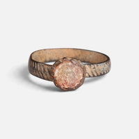 Medieval bronze ring 'Luminara' shows its round pale setting and diagonally incised band from the front.