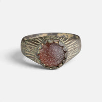 Medieval bronze ring 'Radwina' shows its reddish setting and angular shoulder engraving from the front.