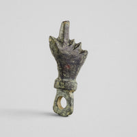 Front view of Roman bronze pendant Manicula, mano fica with the thumb between the folded fingers