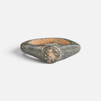 Roman bronze ring 'Aquilarius' shows its worn circular bezel between broad pointed shoulders.