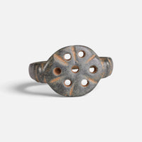 Byzantine bronze ring 'Heliona' shows its seven bezel openings and radiating incised strokes from the front.
