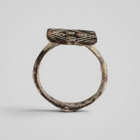 Frontal view of medieval bronze ring Radvan with square diamond-set bezel and geometric motif