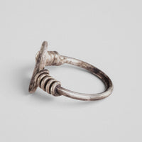 Side view of Roman silver ring Veneria showing the fixed plate edge-on, the coils and the hoop