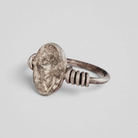 Angled view of Roman silver ring Veneria showing the engraved draped bust plate and coiled shoulders