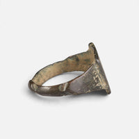 Medieval Islamic bronze ring 'Rashida' shows its broad inner shoulder and the back of its hoop at an angle.