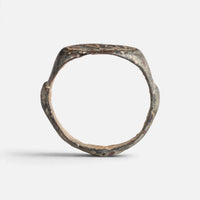 Medieval Islamic bronze ring 'Tahir' shows its full hoop and the broad round bezel edge in profile.