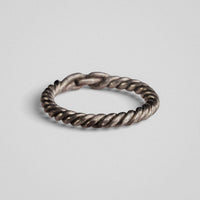 Low-angle view of medieval silver ring Hravnar highlighting tarnish in the grooves of the twist