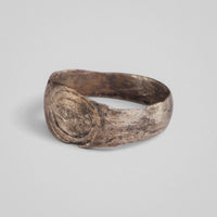 Silver band ring 'Ovata' shows its oval engraving and shoulder decoration from the opposite angle.