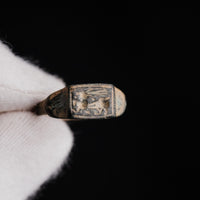 Macro detail of Roman bronze ring Grypho showing incised winged quadruped and patina