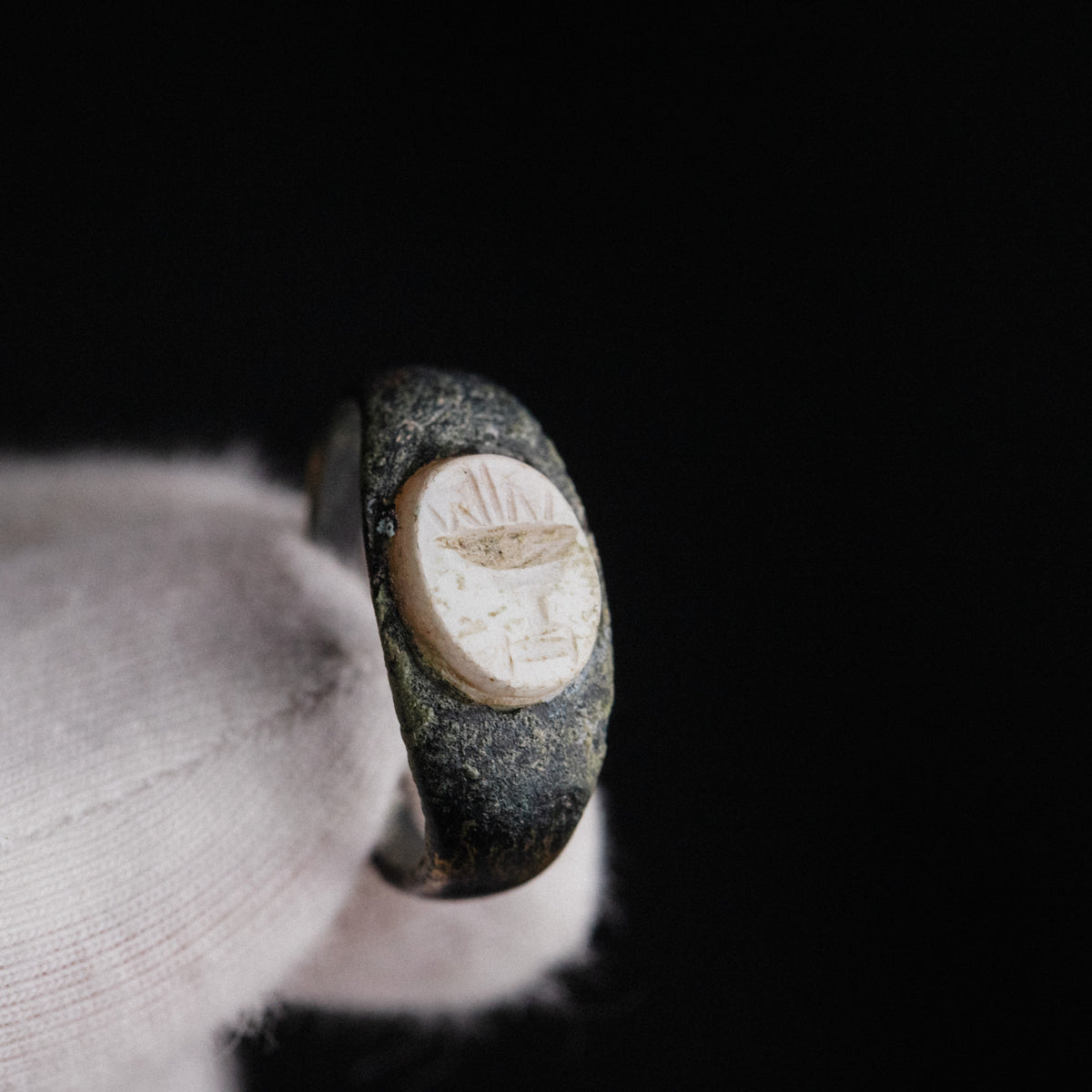 Macro detail of Roman bronze ring Numerius intaglio showing chalice and radiating lines
