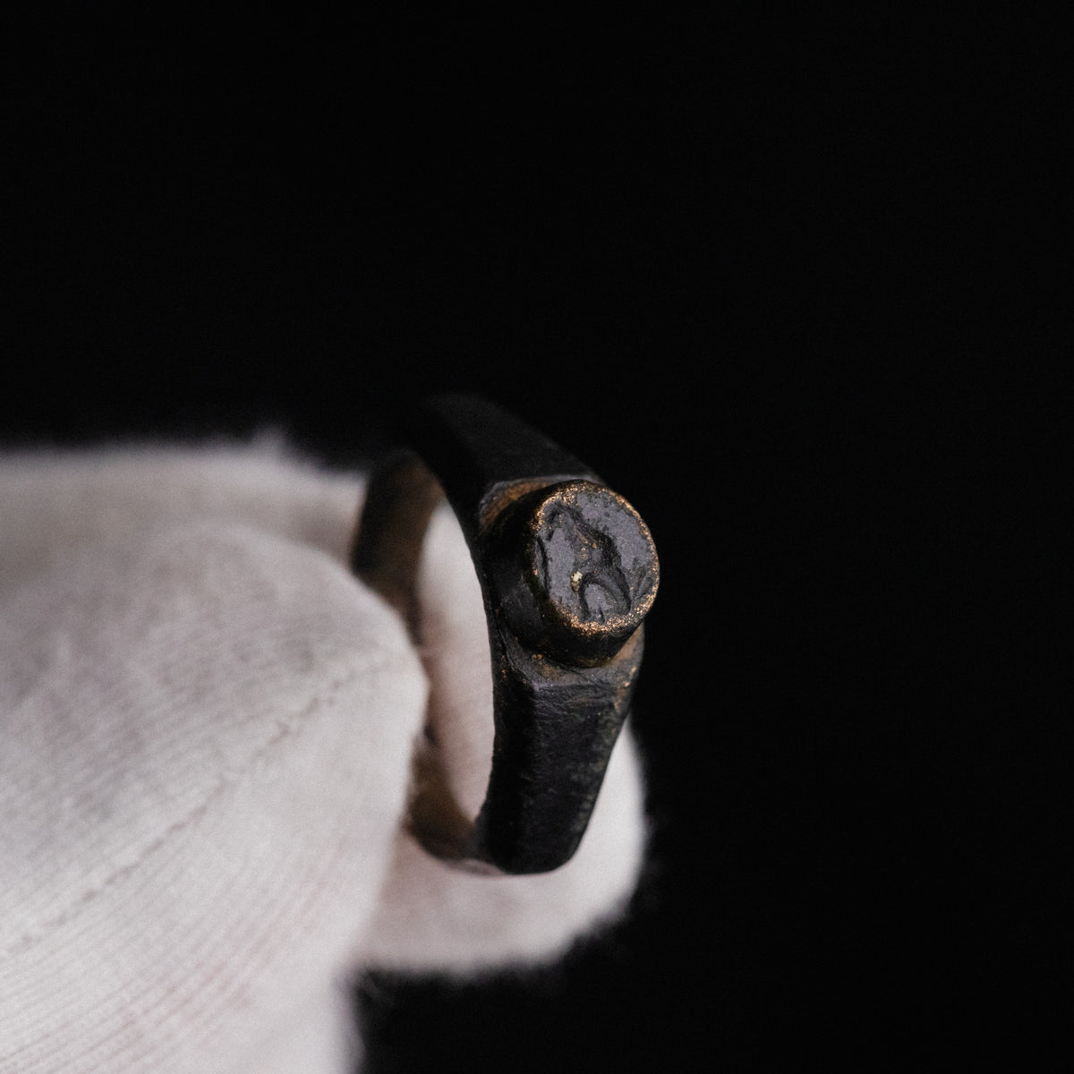 Macro detail of Roman bronze ring Numerius showing worn bird intaglio on bezel