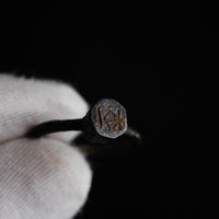 Macro detail of the engraved mirrored-K monogram on Byzantine bronze ring Kyriakos