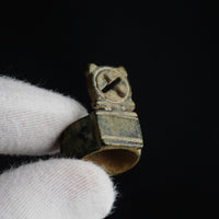Macro view in gloved hand showing openwork cross of Byzantine bronze ring Stavros