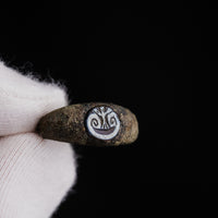 Macro view of nicolo glass paste intaglio on Roman bronze ring Volusia against dark background
