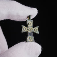 Medieval bronze cross pendant 'Okellos' held in gloved hand, scale reference
