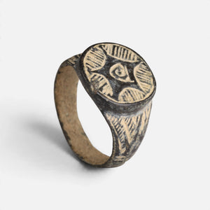 Medieval bronze ring 'Aldebrand' shows its circular geometric bezel and complete broad hoop at an angle.