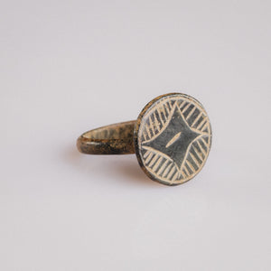 Medieval bronze ring Aldric angled view showing broad disc bezel and Star of Bethlehem motif